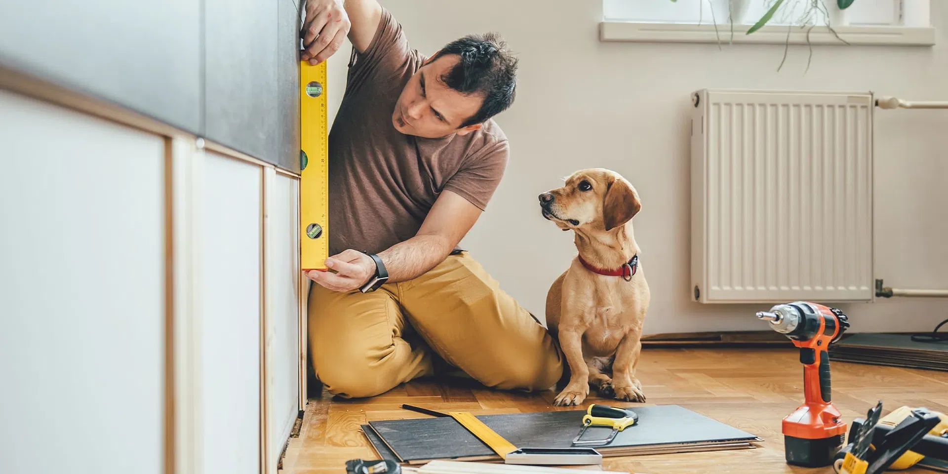Mies remontoi kotiaan kulutusluoton avulla koiran katsoessa vierestä