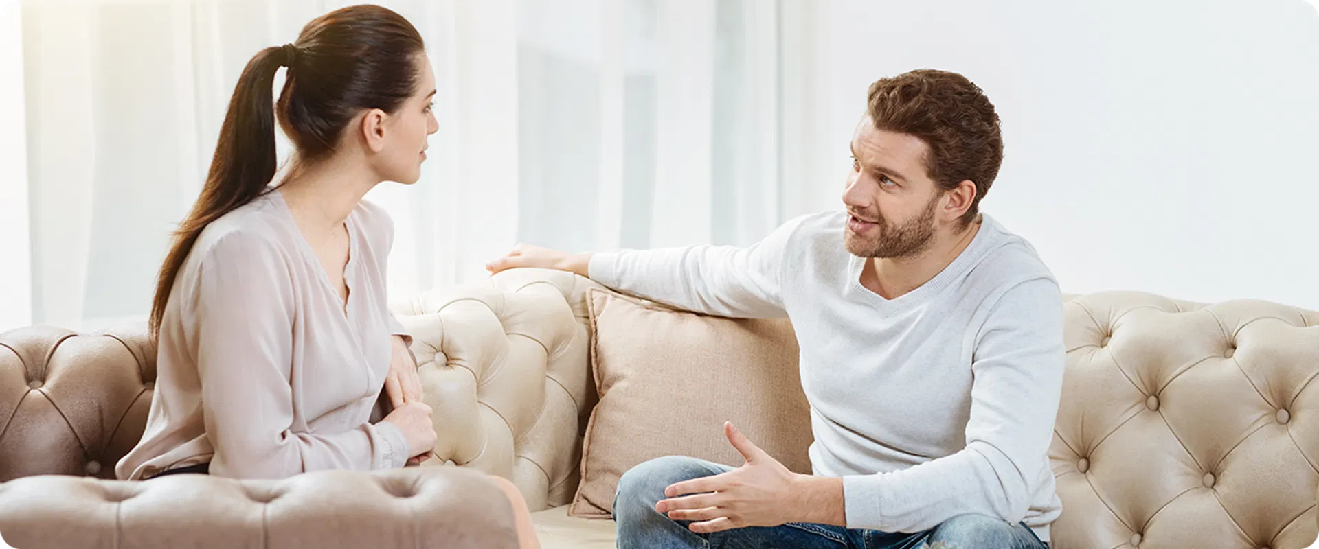 Mies ja nainen keskustelevat lainatarjouksista sohvalla